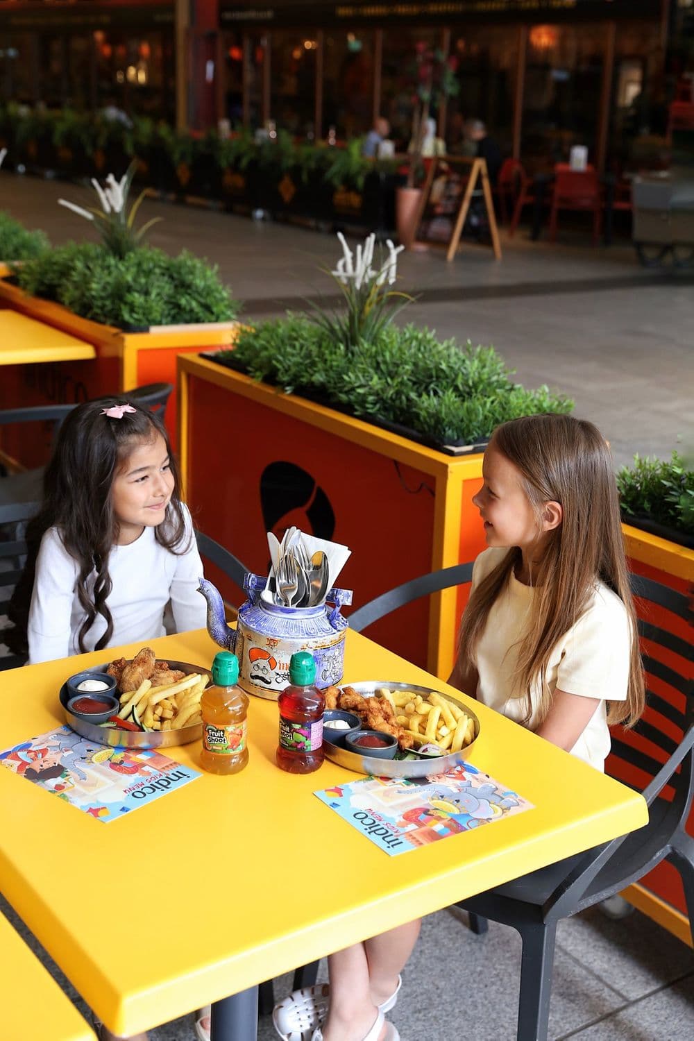 Children at a table outside Indico